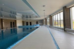 a large swimming pool in a large building at Apartment by Dziwna River with Pool Access in Dziwnów