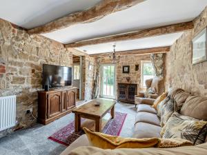 a living room with a couch and a tv at Lakeview Cottage - Uk44099 in Carsington