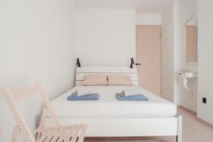 a white bedroom with a bed and a chair at Apartment Vito in Omiš