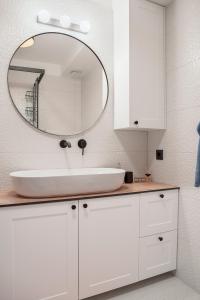 a white bathroom with a sink and a mirror at Apartment Vito in Omiš