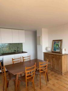 eine Küche mit einem Holztisch und Stühlen in der Unterkunft Maison Gaou Benat, magnifique vue mer in Bormes-les-Mimosas
