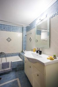 a bathroom with a sink and a tub and a mirror at Villa Olive in Kalamata