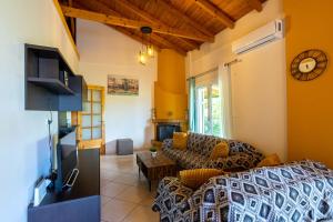a living room with a couch and a tv at Villa Olive in Kalamata