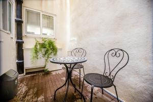 Spacious studio apartment Sliema في سليمة: كرسيين وطاولة على الفناء
