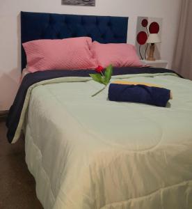 a bed with a pink and blue headboard and a flower on it at "Village" Amplia CASA boutique con parrilla y 2 garages in Corrientes
