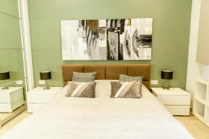 Spacious studio apartment Sliema في سليمة: غرفة نوم بسرير كبير مع مواقف ليلتين