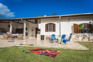 un patio con sillas y una alfombra en el césped en Casa vista para montanha Pet Friendly en Caraguatatuba