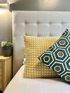 a bed with a white headboard and a pillow at Hotel La Calanque in Mandelieu-La Napoule