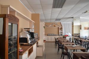 un restaurante con mesas y sillas y una cafetería en Hotel Altinate, en Lido di Jesolo