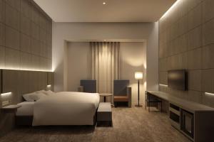 福岡市にあるHOTEL IL PALAZZO - Vacation STAY 68269vの白いベッドとテレビが備わるホテルルームです。