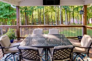 a table and chairs on a screened porch with trees at Anderson Lakefront Vacation Rental with Boat Dock! in Anderson