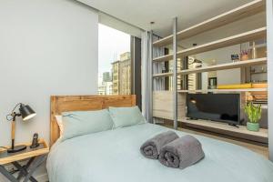 a bedroom with a bed with towels on it at Luxury Building in Convenient Location w Full Power in Cape Town