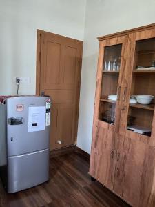 a kitchen with a refrigerator and a wooden cabinet at Sunshine Beach Villa - Kuzhuppilly in Cherai Beach