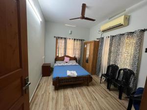 a bedroom with a bed and a ceiling fan at Sunshine Beach Villa - Kuzhuppilly in Cherai Beach