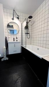 W łazience znajduje się wanna, umywalka i lustro. w obiekcie Saperówa w Poznaniu
