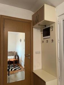 eine Küche mit einer Tür zu einem Zimmer mit einem Tisch in der Unterkunft JANA in Veliko Gradište