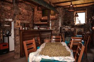 a dining room with a table and chairs and a bar at Na krovu svijeta in Lukomir