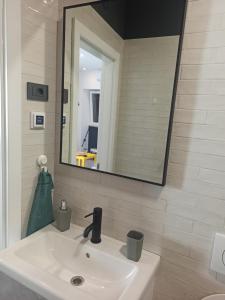een badkamer met een witte wastafel en een spiegel bij GrannyAnny in Šibenik