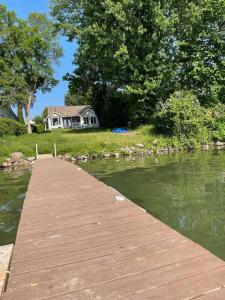 un muelle de madera frente a una casa en un lago en The Waterfront Paradise, en Orillia