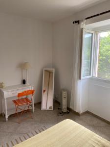 Schlafzimmer mit einem Schreibtisch, einem Stuhl und einem Fenster in der Unterkunft Maison tranquillité in Montégut-Plantaurel