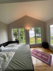 1 dormitorio con 1 cama y 2 ventanas grandes en The Waterfront Paradise, en Orillia