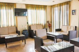 un soggiorno con sedie, tavoli e TV di Panorama Hotel a Karpathos