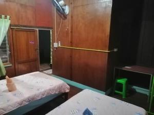 Habitación pequeña con 2 camas y puerta en Lungmin homestay, en Mae Hong Son