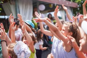 a group of children with their hands in the air at Boemul Neptun in Neptun