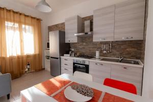 eine Küche mit einem Tisch, einer Spüle und einem Kühlschrank in der Unterkunft Aela Home in Pisa