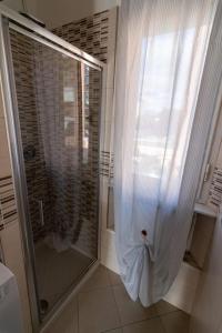 La salle de bains est pourvue d'une douche et d'une porte en verre. dans l'établissement Aela Home, à Pise