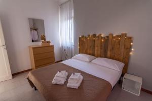 ein Schlafzimmer mit einem großen Bett mit zwei Handtüchern darauf in der Unterkunft Aela Home in Pisa
