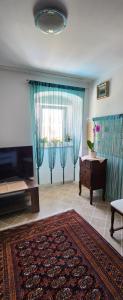 uma sala de estar com cortinas azuis, uma televisão e uma mesa em Vila Jenny em Hreljin