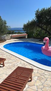 a swimming pool with a pink flamingo and a float at Apartmani Pero Dido in Rab