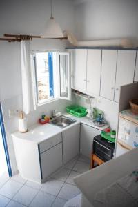 a small kitchen with a sink and a window at Michalis little sunrise in Mamádhos