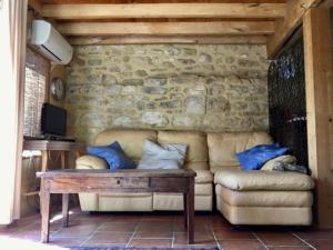 a living room with a couch and a table at Esparoutis in Saint-Cybranet