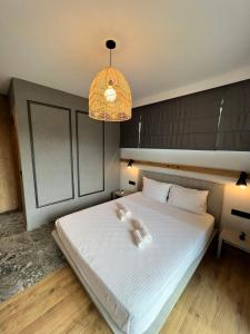 sypialnia z dużym białym łóżkiem z oświetleniem w obiekcie Villas Park Lozenets w Łozencu