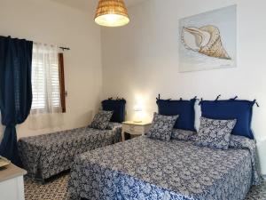 a bedroom with two beds and a lamp at Roda' in Panarea