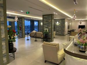a lobby with a waiting room with couches and flowers at فندق حياة تاون 2 in Umm Lujj