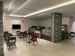 uma sala de espera com cadeiras, uma mesa e um bar em فندق حياة تاون 2 em Umm Lajj