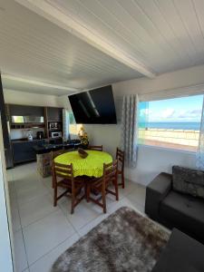 a living room with a table and chairs and a kitchen at Flat Morro de São Paulo e Casa Blanca in Morro de São Paulo