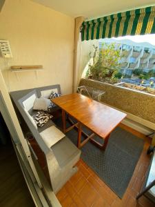 a small room with a table and a bench and a window at Studio 237 Port Camargue, Piscine, Climatisation, 2 personnes in Le Grau-du-Roi