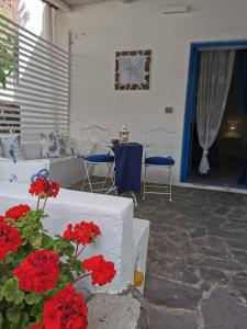 a patio with red flowers and a table and chairs at Roda' in Panarea
