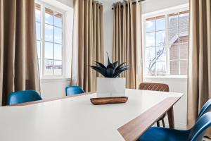 a meeting room with a white table and blue chairs at Bright & Modern Retreat - King Beds - Sloans Lake in Denver