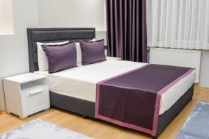 een slaapkamer met een groot bed met paarse kussens bij Stile Suite Large House, Konyaalti ,500 meters on the beach in Antalya