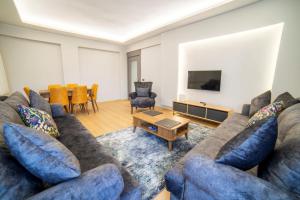 een woonkamer met een bank en een tv bij Stile Suite Large House, Konyaalti ,500 meters on the beach in Antalya