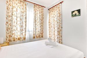 a bedroom with a white bed with curtains and a window at Espanhouse Alina in Orihuela Costa