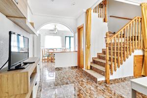 a living room with a staircase and a television at Espanhouse Alina in Orihuela Costa