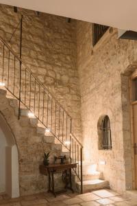 a staircase in a stone building with a wooden table at William's Guest House in Jerusalem