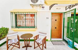 a patio with two chairs and a table and a door at Espanhouse Sonia in La Zenia Playas de Orihuela in Orihuela