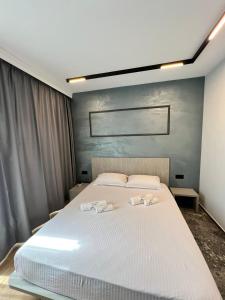 a bedroom with a large white bed with towels on it at Villas Park Lozenets in Lozenets